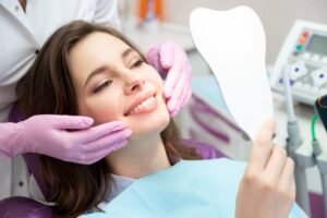 A woman admiring the results of her cosmetic dental treatment